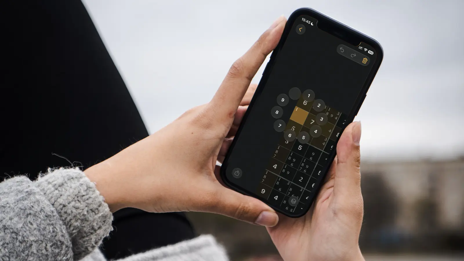 A hand using CharGrid’s circular number control on iPhone